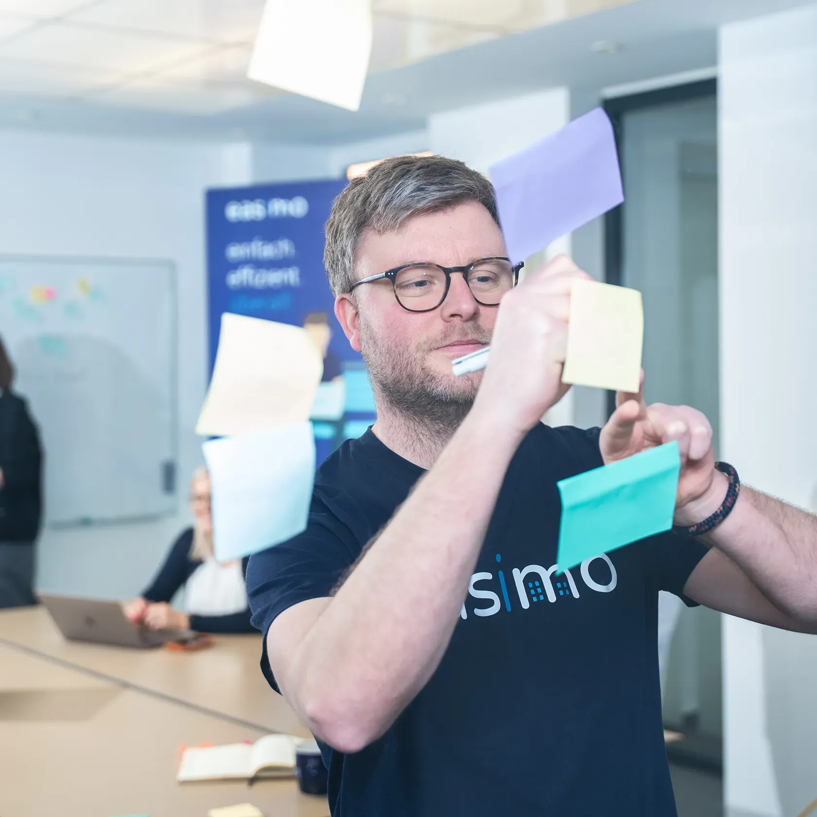 Mitarbeiter von easimo arbeitet mit Haftnotizen an Ideen für die All-in-one-Softwarelösung zur digitalen Immobilienverwaltung.