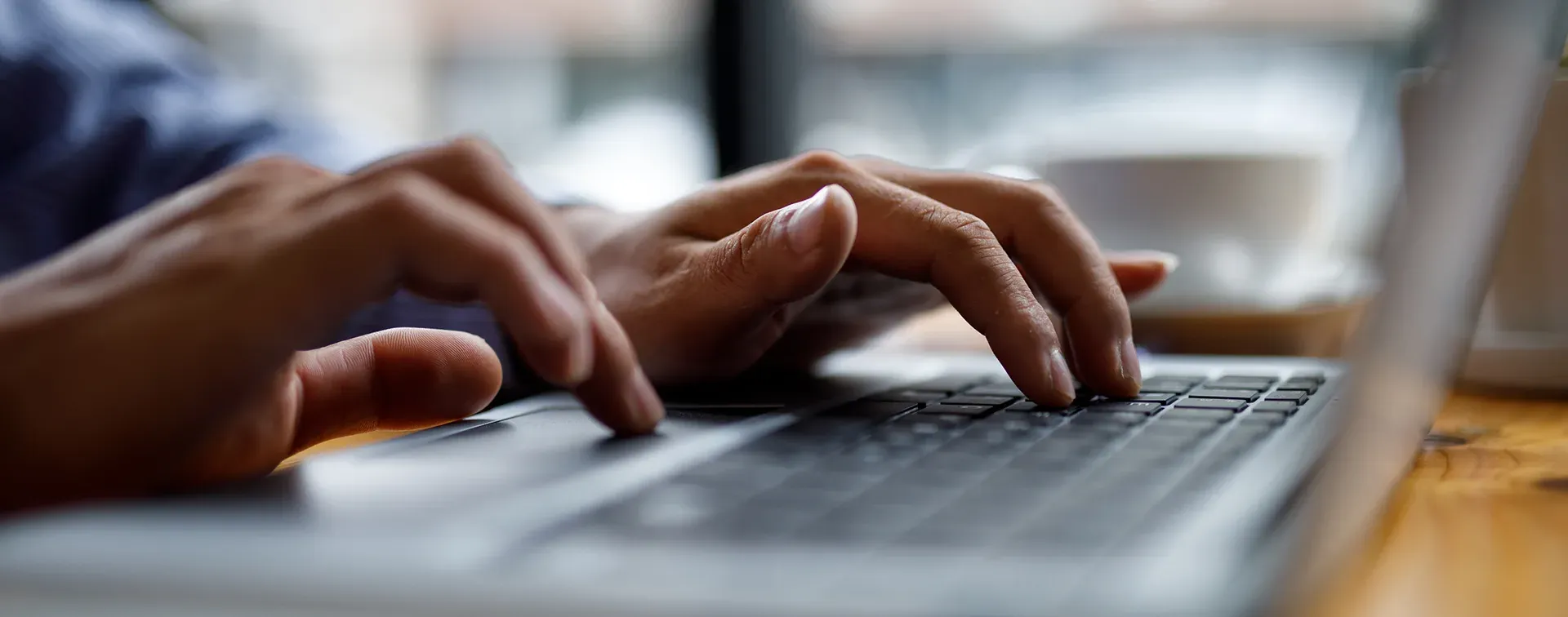 Person arbeitet an einem Laptop mit Programmcode fĂĽr digitale Immobilienverwaltungssoftware.